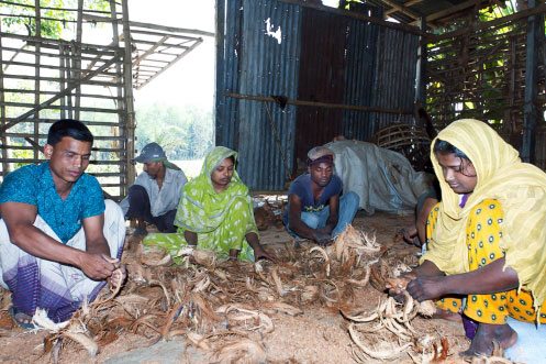 Mennesker lager tepper av kokosnøttråder