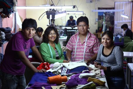 Mennesker samlet rundt tekstilarbeid.