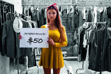 Jente med gul kjole med skilt "Jeg kjøpte denne for $50"