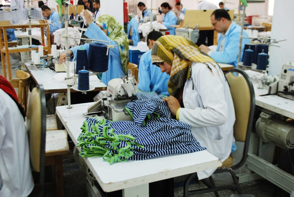 Kvinne ved symaskin i fabrikk