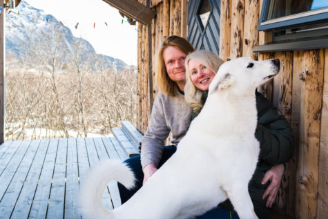 Mann og kvinne med hund utenfor inngang til hus.