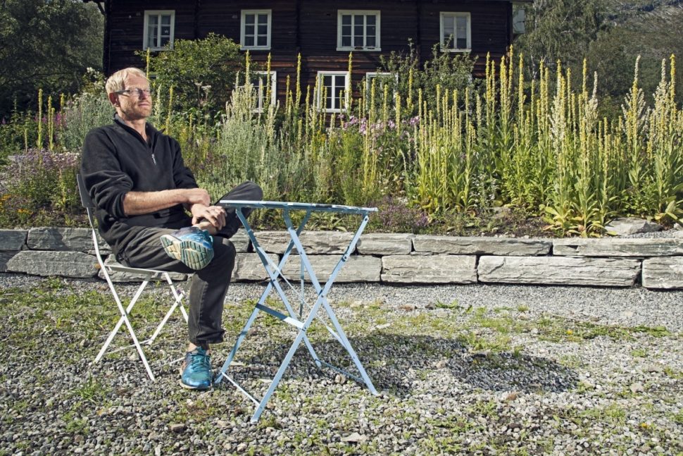 Ola Aukrust sitter på en stol i urtehagen