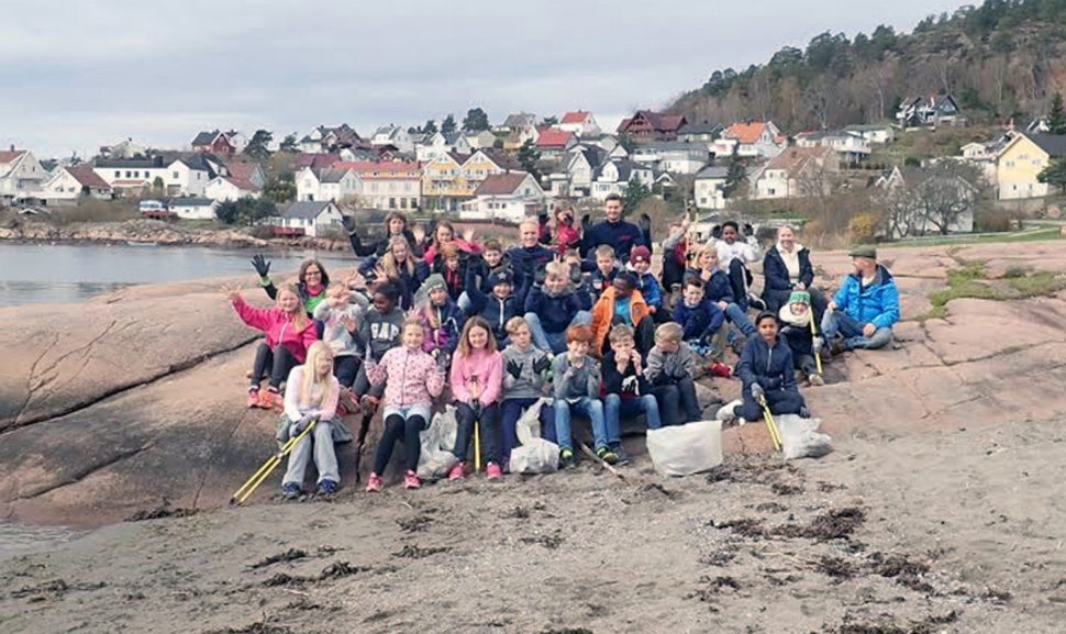 Gruppe av barn rydder strand