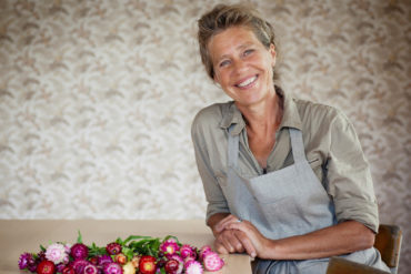 Kvinne ved bord med blomster