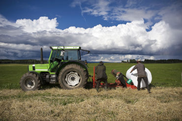 Mennesker jobber ved traktor på jorde