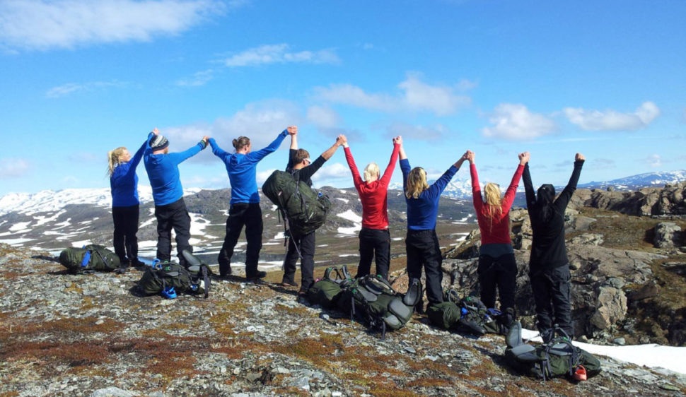 Jublende mennesker på en fjelltopp