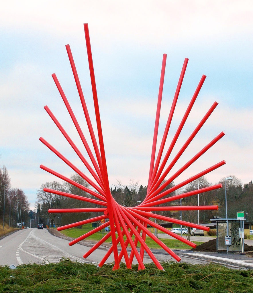 Abstrakt rød jernskulptur ved hovedvei