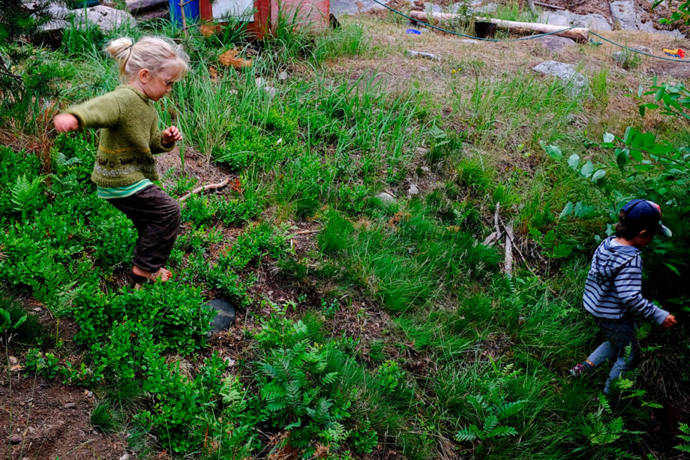 Barn i høy aktivitet i grøntområde med planter