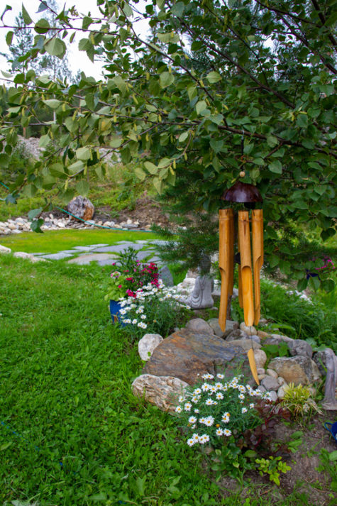 Arrangement med blomster og planter i hage.