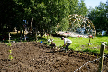 Mennesker jobber med dyrket jord i landlig landskapl