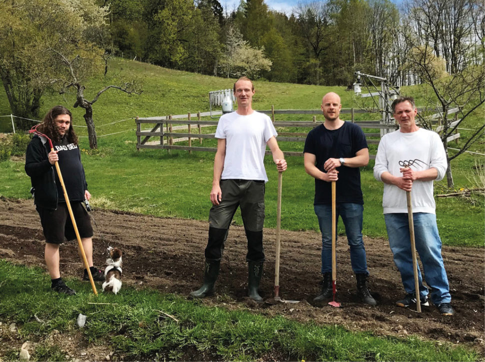 Fire menn med raker i landlige omgivelser