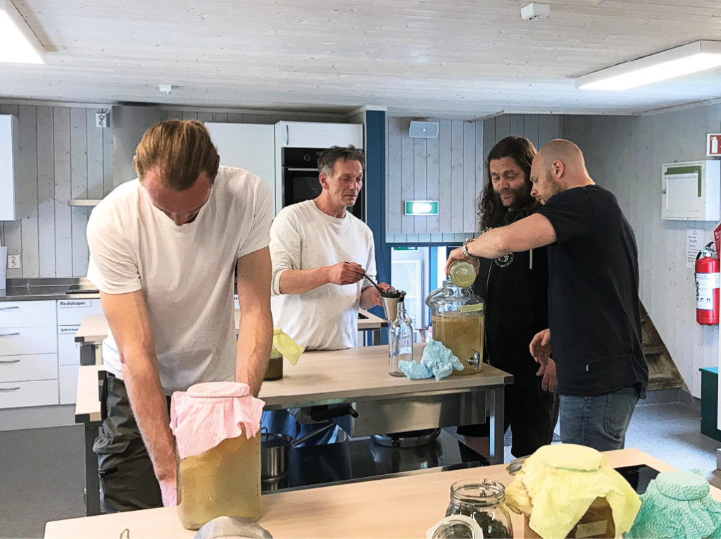 Fire menn jobber med matvarer i kjøkken