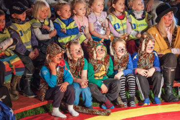 Barn i kostymer er tilskuere på sirkus