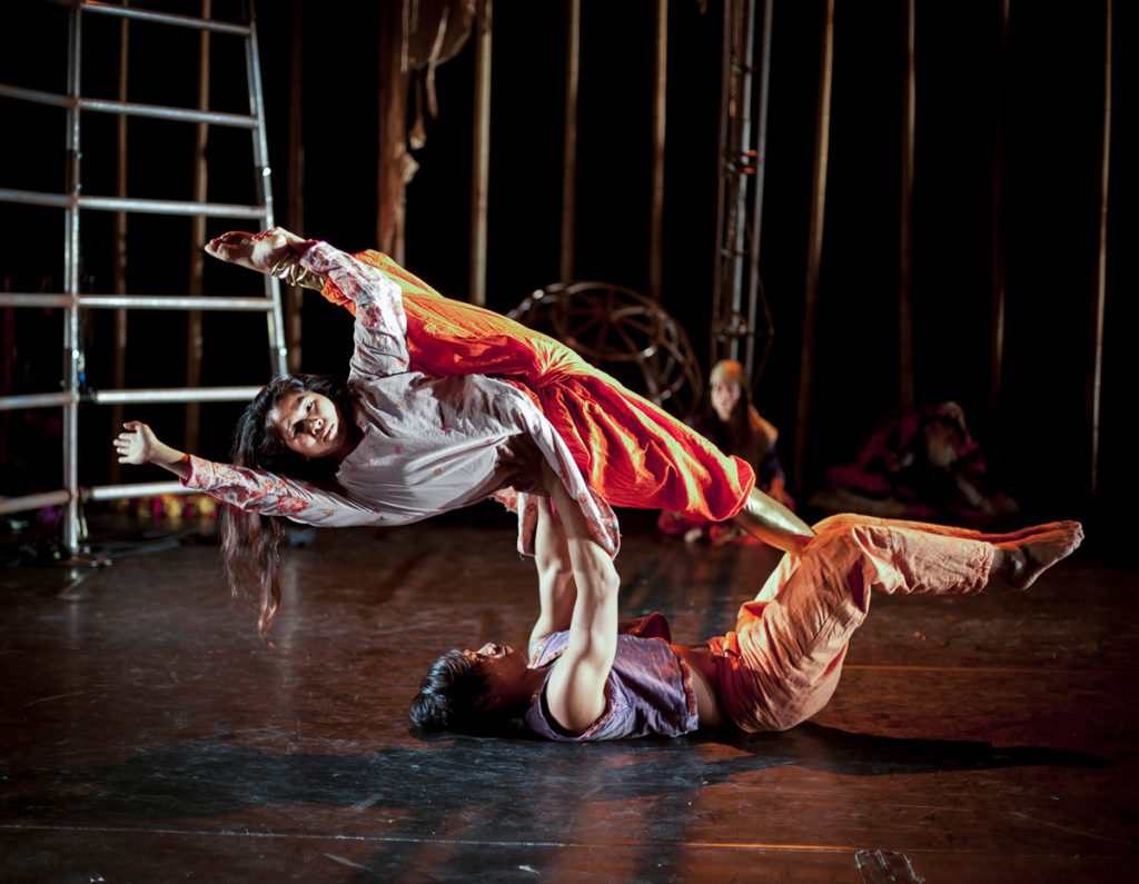 Sirkuskunstnere i akrobatiske øvelser på scenen