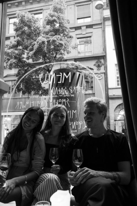 Tre venner nyter et glass vin i en bar