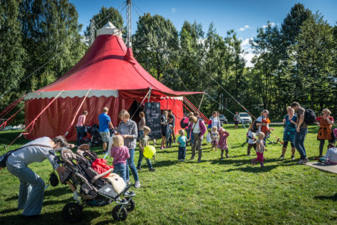 Lite, rødt cirkustelt i sommerlig parkområde