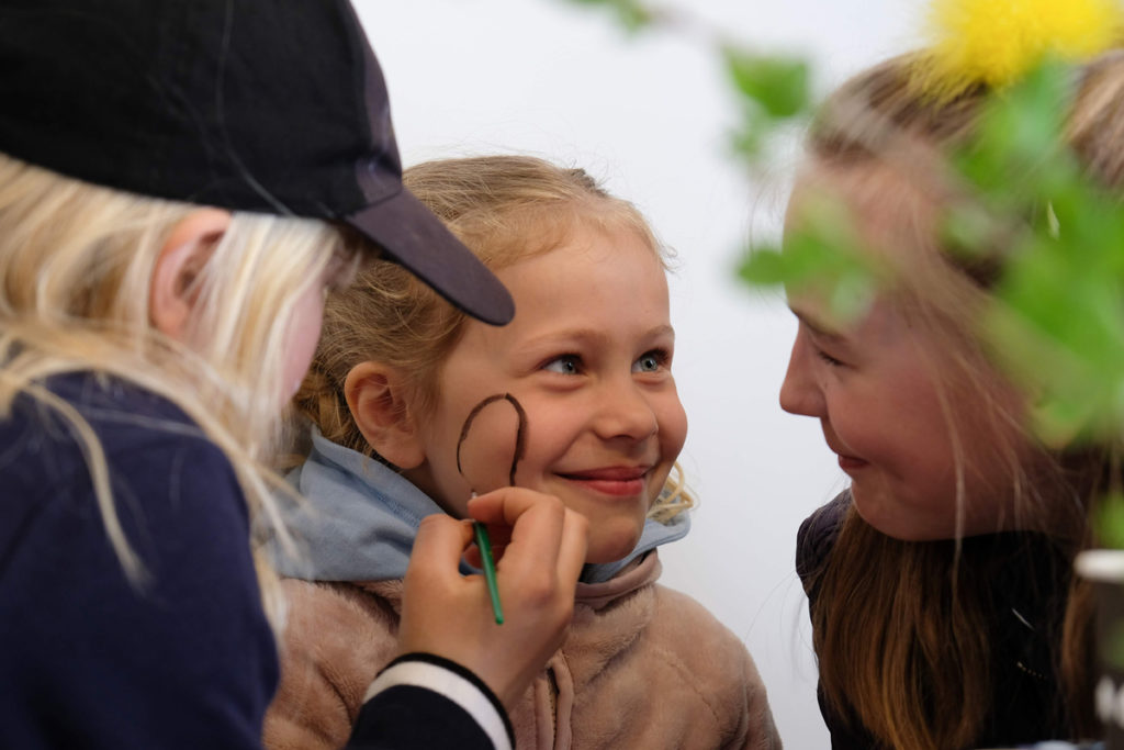 Barn får ansiktsmaling av to voksne