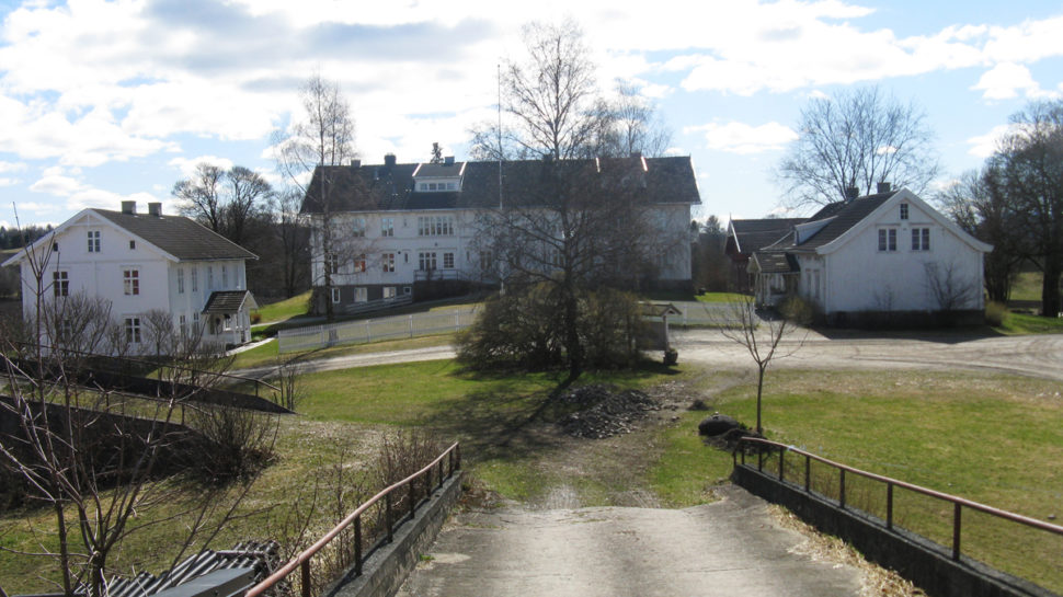 Gårdstun i landlige omgivelser med gårdsvei i forkant.