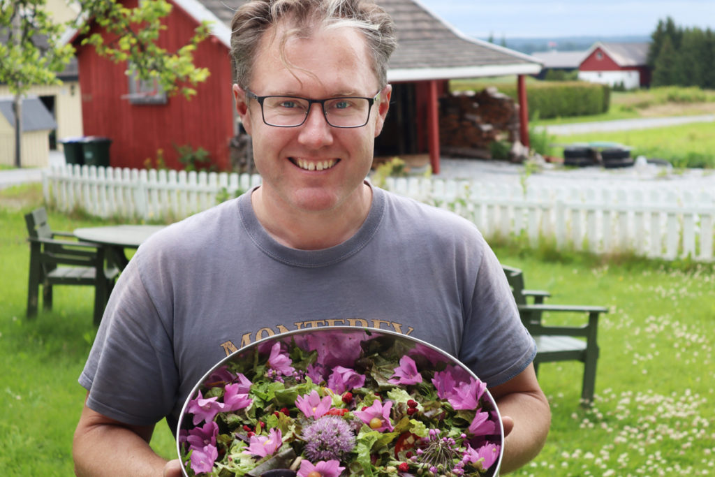 Mann viser fram stålbolle med blomster