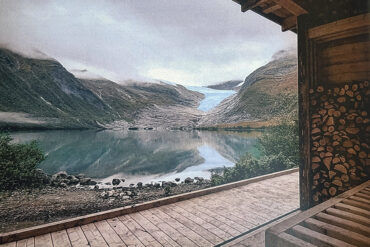 Utsikt mot fjord og fjell fra innsiden av sauna.