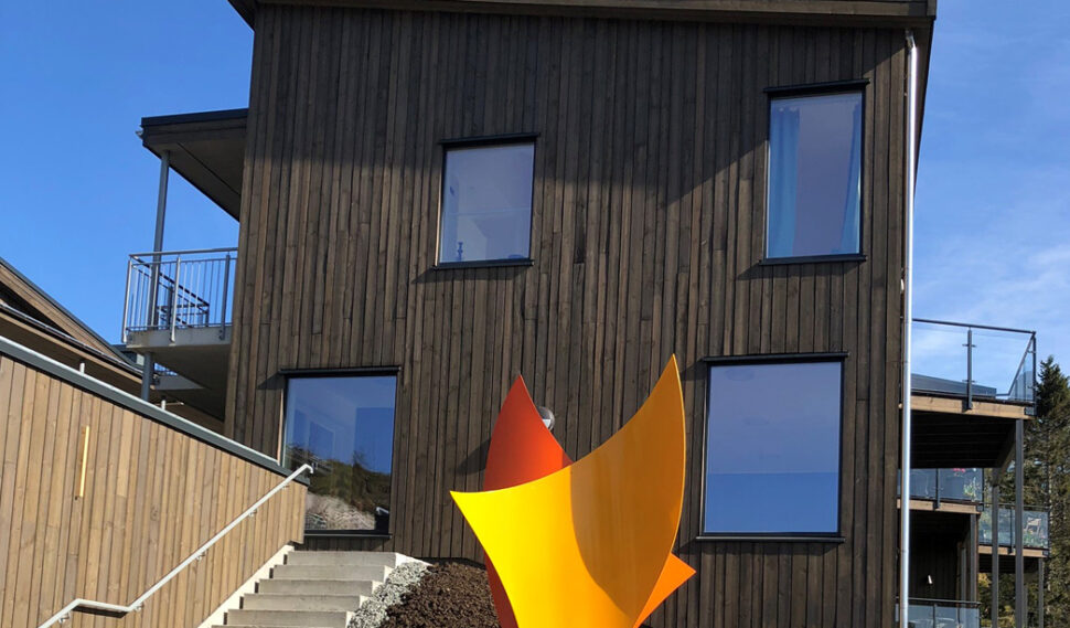 Brun bygning med gul skulptur i forkant.