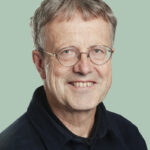 Portrett av person med briller og svart genser.