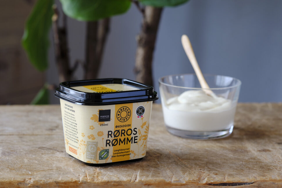 Bord med en pakke rømme og et glass med pakkens innhold ved siden av.