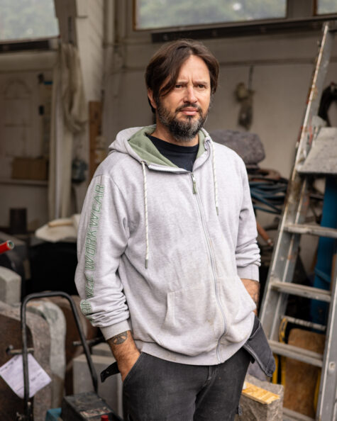 Person iført hvit genser i et verksted.