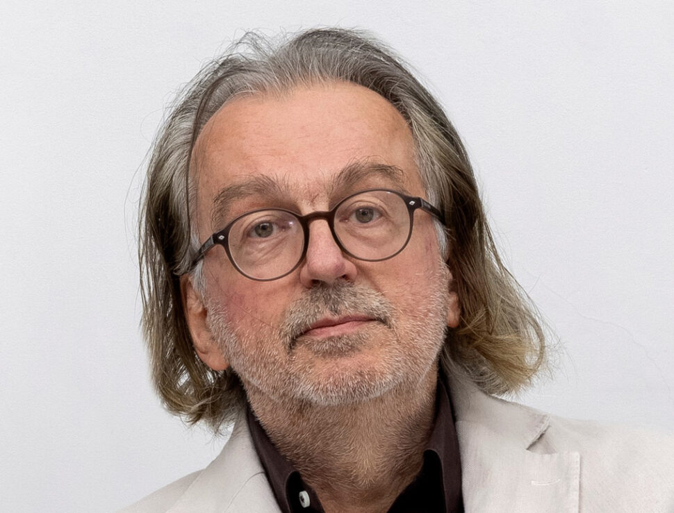 Portrett av person med briller og hvit jakke